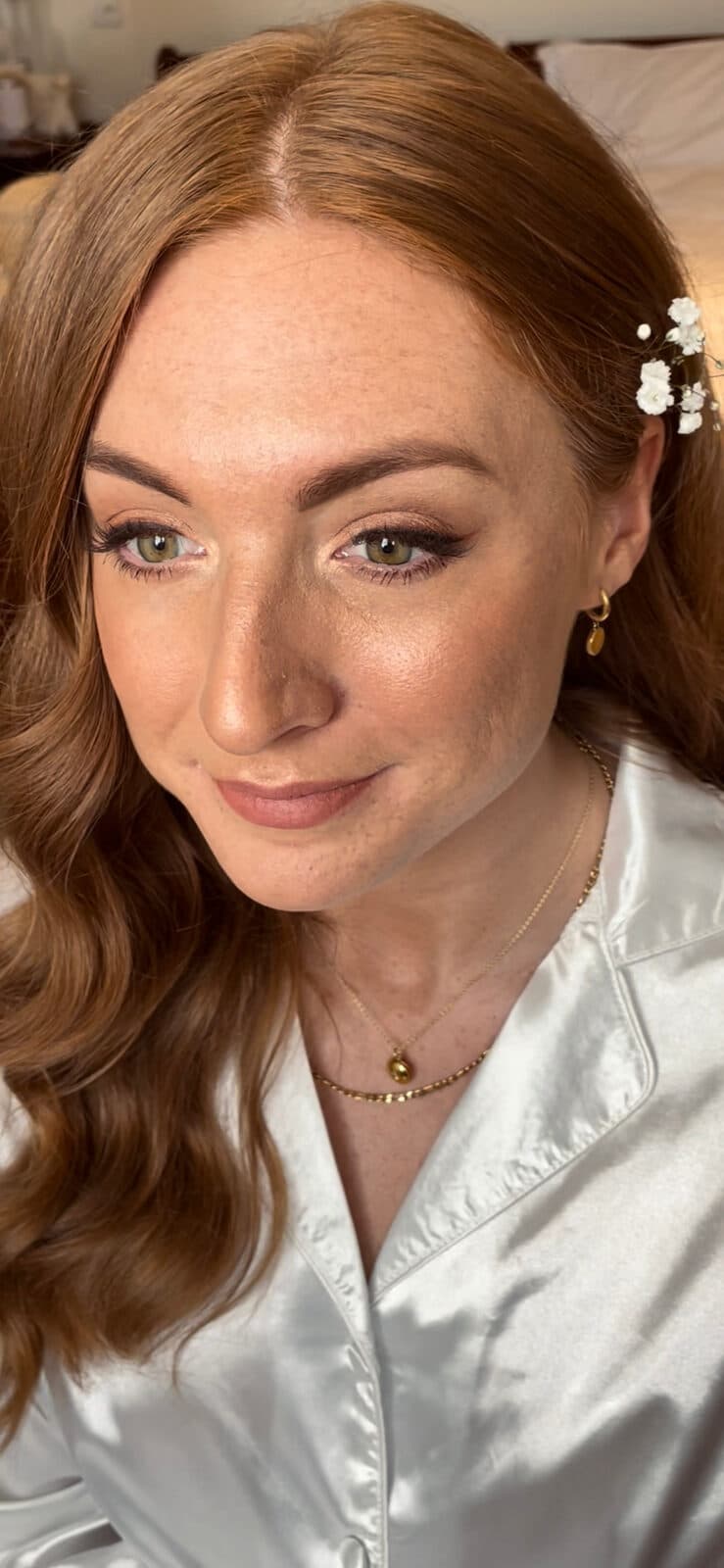 Red-haired bride in a satin robe on the morning